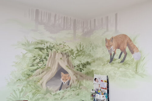 malba na zeď v dětském pokoji Realistická malba na zeď v dětském pokoji zobrazující lesní zátiší s liškami.